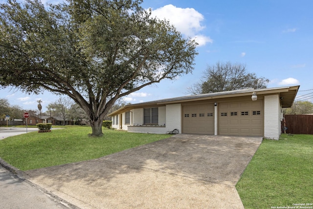 ranch-style house with fence, a front lawn, concrete driveway, and an attached garage