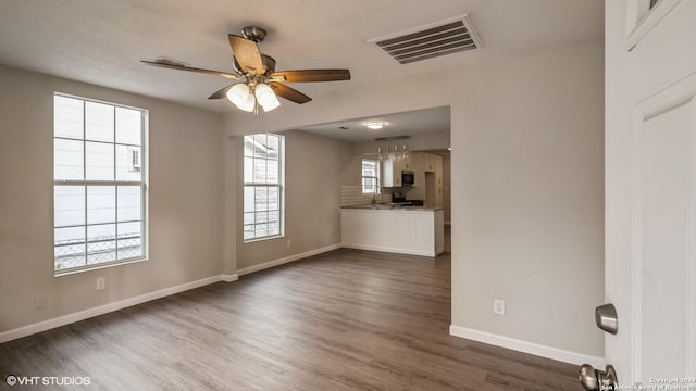 unfurnished living room with ceiling fan and dark hardwood / wood-style floors