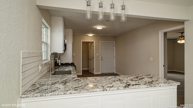 kitchen with sink, white cabinetry, and light stone counters