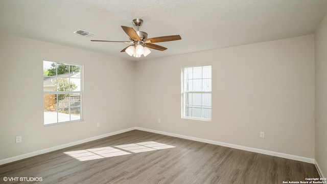 unfurnished room with ceiling fan, hardwood / wood-style flooring, and a textured ceiling