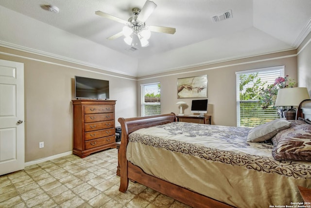 bedroom with ceiling fan, crown molding, multiple windows, and a tray ceiling