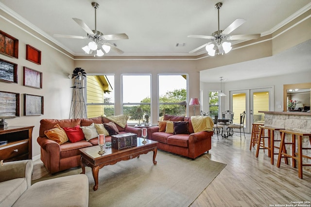 living room featuring ornamental molding, light wood-type flooring, and ceiling fan