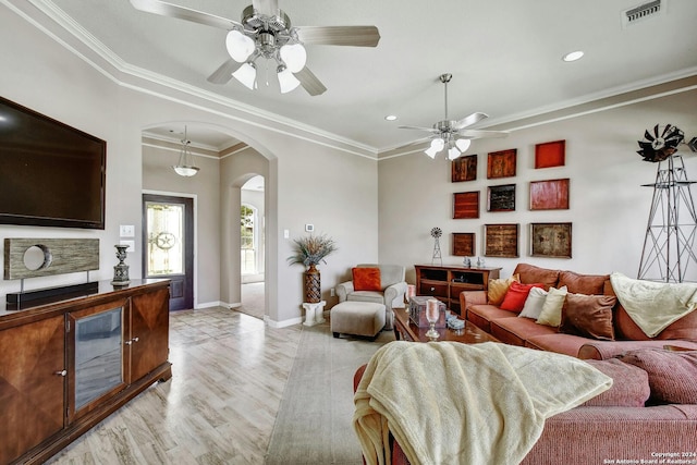 living room with light hardwood / wood-style floors, ornamental molding, and ceiling fan