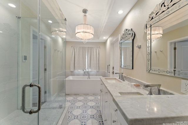 bathroom featuring vanity, a notable chandelier, and separate shower and tub