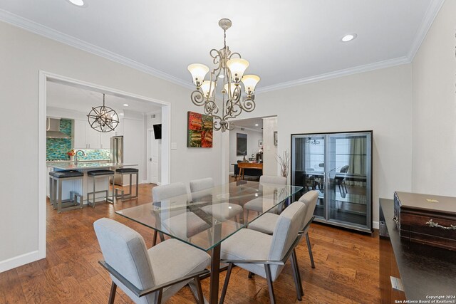 dining room featuring dark wood-type flooring, a notable chandelier, and ornamental molding