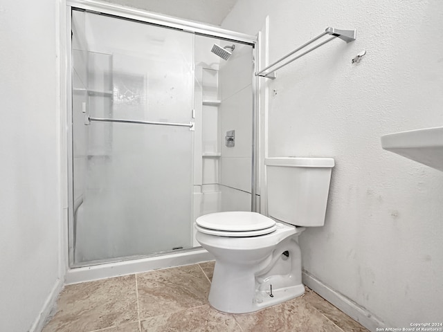 bathroom featuring toilet and an enclosed shower