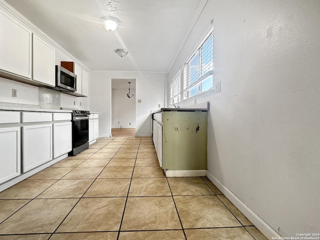 7114 Teton Rdg, San Antonio, TX 78233 - kitchen with stainless steel microwave, light tile patterned floors, crown molding, white cabinets, and electric range
