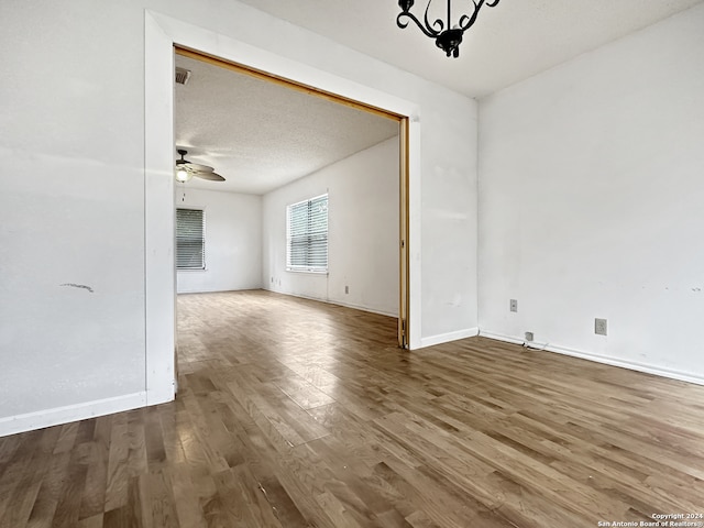 unfurnished dining area with a textured ceiling, hardwood / wood-style flooring, and ceiling fan