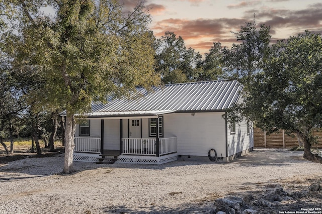 1627 Forest Lake Dr, Spring Branch, TX 78070 - view of front of house featuring a porch, fence, metal roof, and crawl space