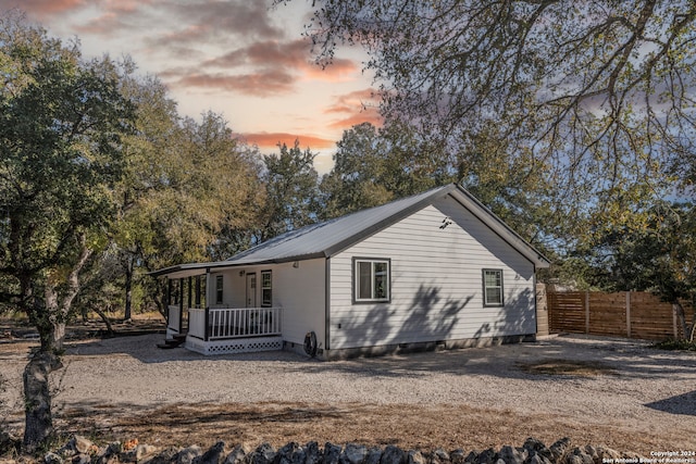 back house at dusk with covered porch