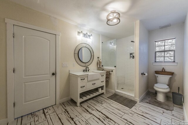 1627 Forest Lake Dr, Spring Branch, TX 78070 - full bathroom featuring toilet, wood finished floors, a tile shower, baseboards, and vanity
