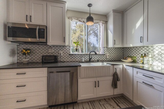 1627 Forest Lake Dr, Spring Branch, TX 78070 - kitchen with a toaster, a sink, decorative backsplash, dark countertops, and stainless steel appliances