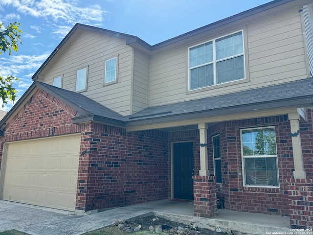 view of front of property featuring covered porch and a garage