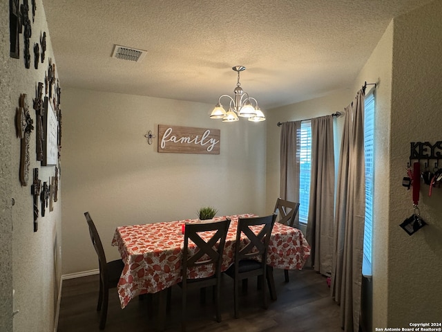 dining area featuring a notable chandelier, a textured ceiling, and dark hardwood / wood-style flooring