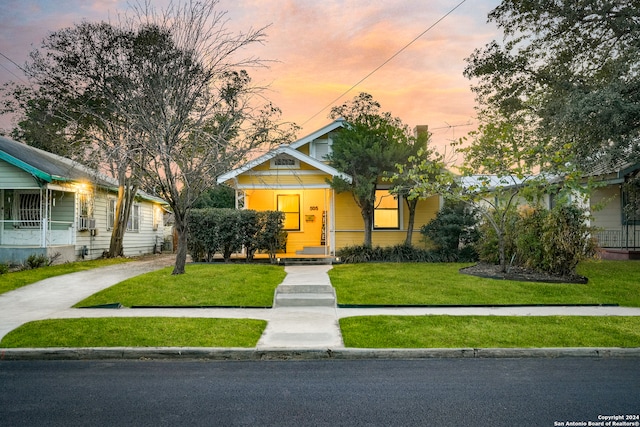 bungalow featuring a yard and cooling unit