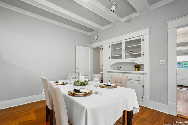 dining space featuring beam ceiling, ornamental molding, and dark wood-type flooring