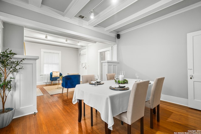 dining area with ornamental molding, hardwood / wood-style floors, and beam ceiling