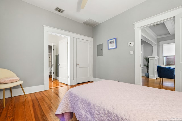 bedroom featuring a closet, ceiling fan, hardwood / wood-style flooring, and electric panel