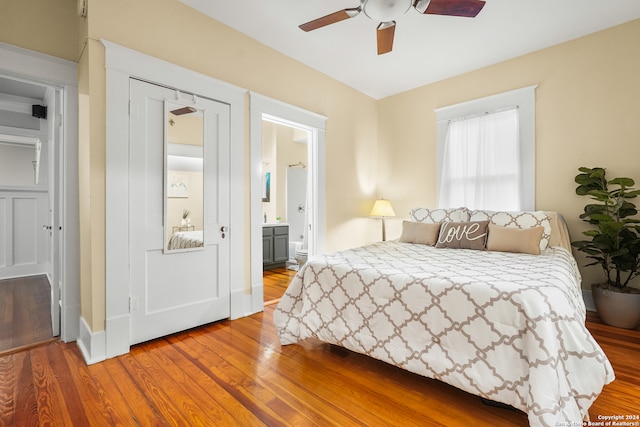 bedroom featuring ensuite bath, wood-type flooring, a closet, and ceiling fan