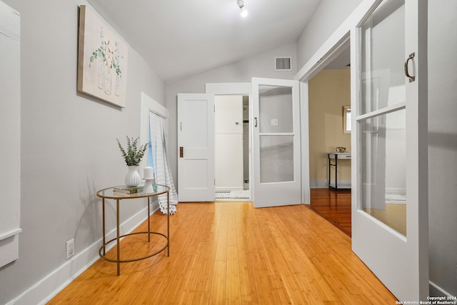 entrance foyer featuring hardwood / wood-style flooring and vaulted ceiling