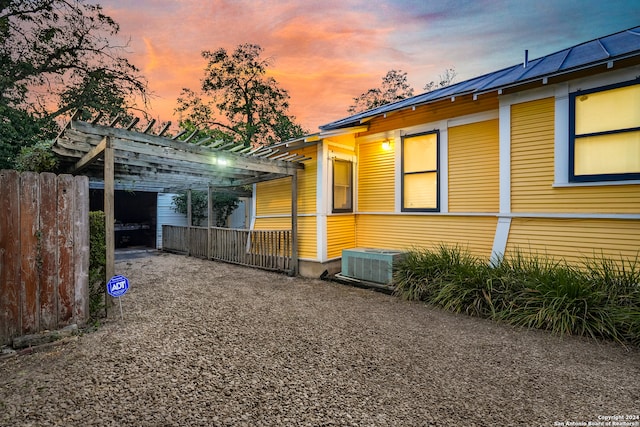 property exterior at dusk featuring cooling unit