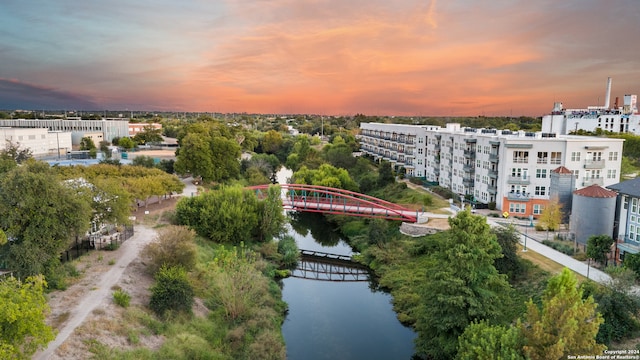 aerial view at dusk featuring a water view