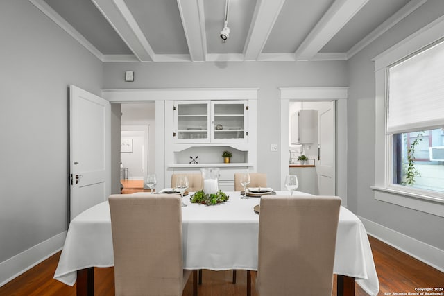 dining space featuring beamed ceiling, dark wood-type flooring, and crown molding