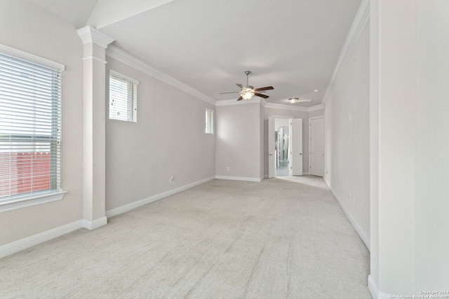 carpeted empty room with crown molding, decorative columns, and ceiling fan