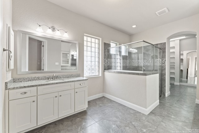 bathroom featuring vanity and a shower with door