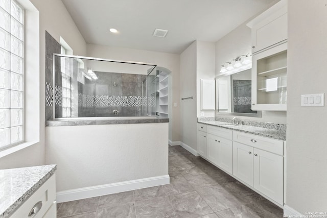 bathroom with vanity and a tile shower