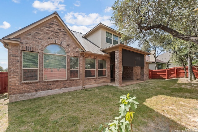 rear view of property featuring a yard