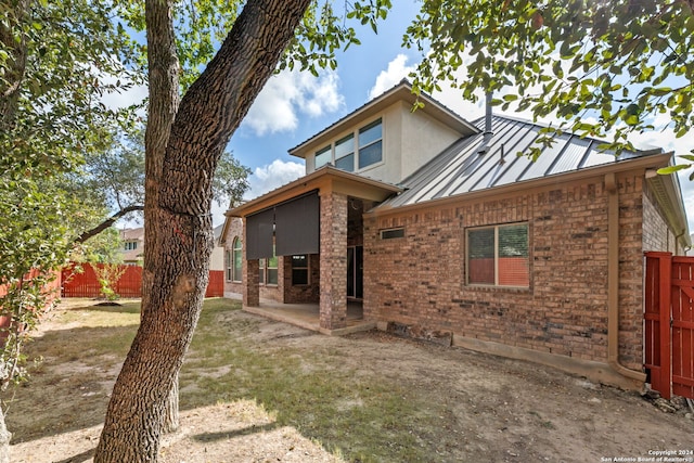 rear view of property with a patio area and a lawn