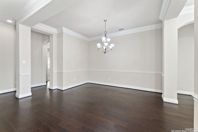 spare room featuring an inviting chandelier, ornamental molding, and dark wood-type flooring