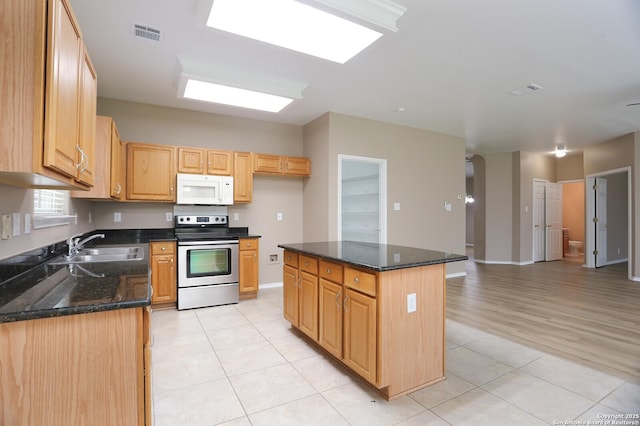 14514 Redwood Vly, Helotes, TX 78023 - kitchen featuring stainless steel range with electric stovetop, white microwave, light tile patterned flooring, a sink, and dark stone counters