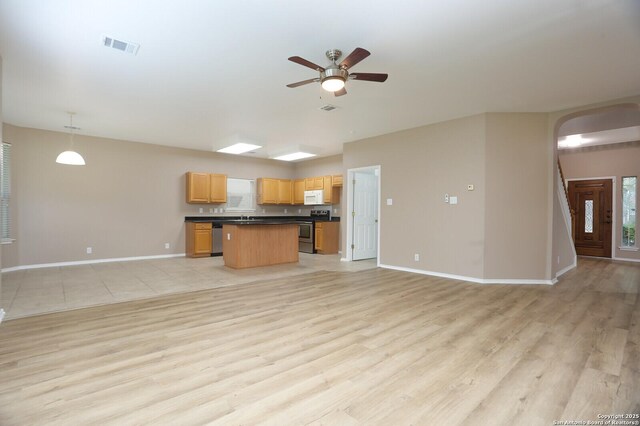 14514 Redwood Vly, Helotes, TX 78023 - kitchen with stainless steel appliances, open floor plan, dark countertops, arched walkways, and a ceiling fan