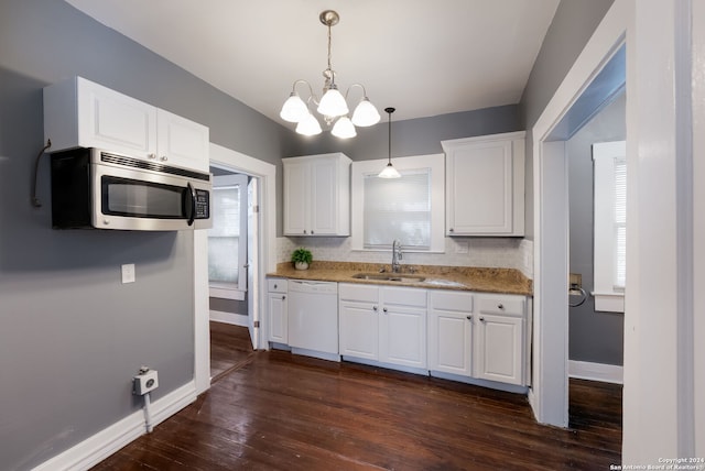 kitchen featuring sink, dishwasher, a wealth of natural light, pendant lighting, and white cabinets