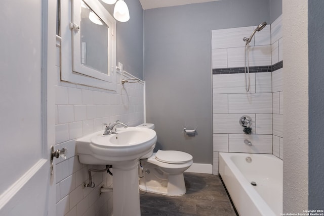 bathroom featuring toilet, wood-type flooring, decorative backsplash, and tiled shower / bath