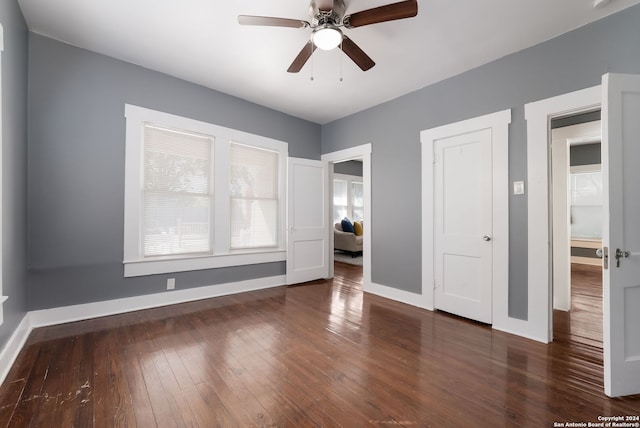 unfurnished bedroom featuring ceiling fan and dark hardwood / wood-style flooring