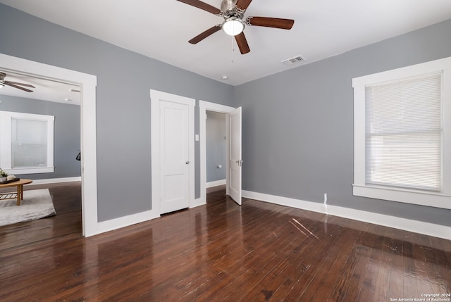 unfurnished bedroom featuring ceiling fan and dark hardwood / wood-style flooring