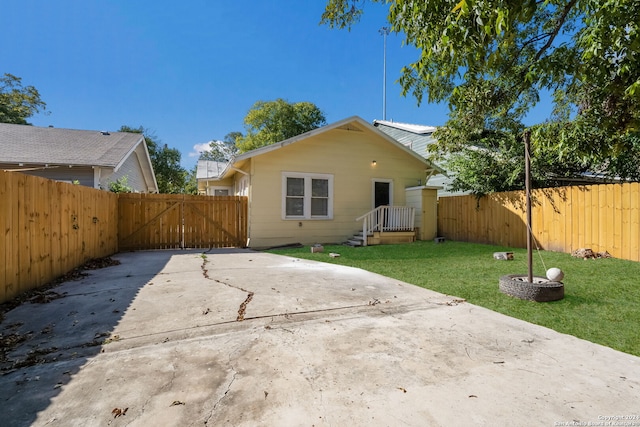 back of property with a patio and a lawn