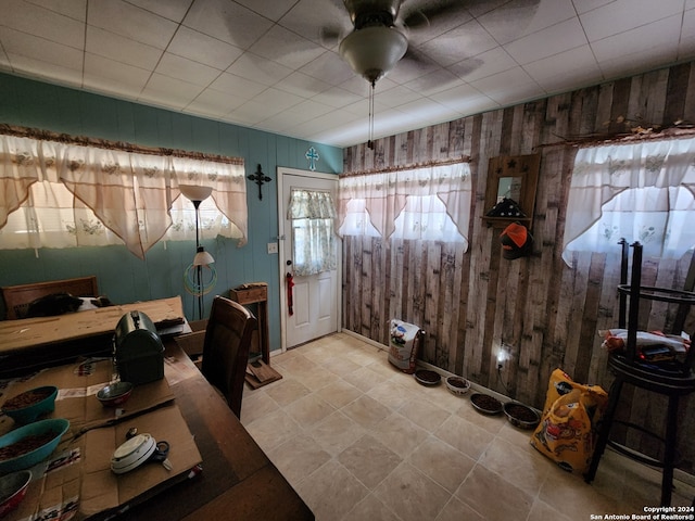 foyer with wooden walls and ceiling fan