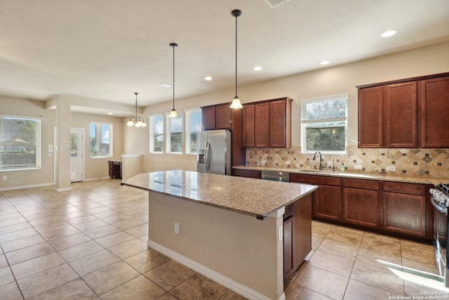 kitchen featuring sink, appliances with stainless steel finishes, light stone counters, and tasteful backsplash