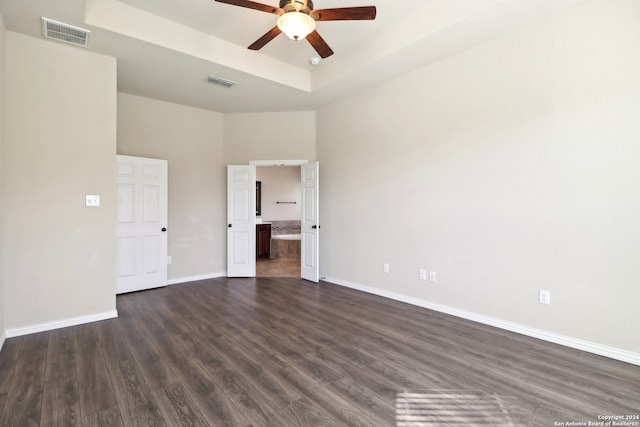 empty room with a towering ceiling, dark hardwood / wood-style floors, and ceiling fan