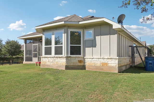 view of home's exterior with a yard and a sunroom