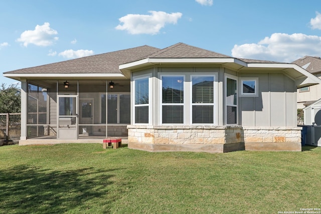 rear view of property featuring a lawn and a sunroom