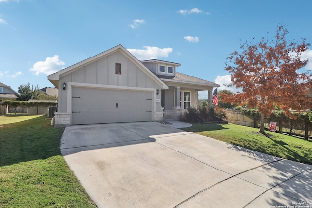 view of front of property featuring a front yard, a garage, and central AC unit