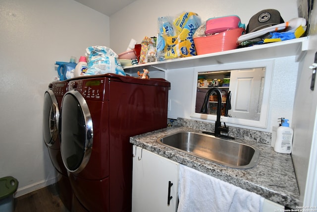 clothes washing area with washer and dryer, cabinets, sink, and hardwood / wood-style floors