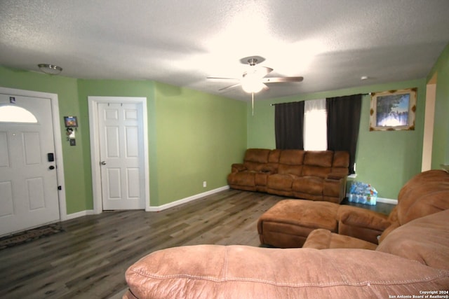 living room featuring a textured ceiling, ceiling fan, and dark hardwood / wood-style flooring