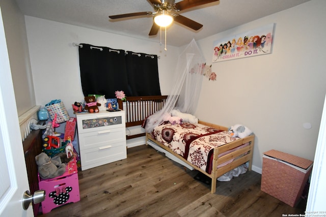 bedroom with ceiling fan and dark hardwood / wood-style flooring