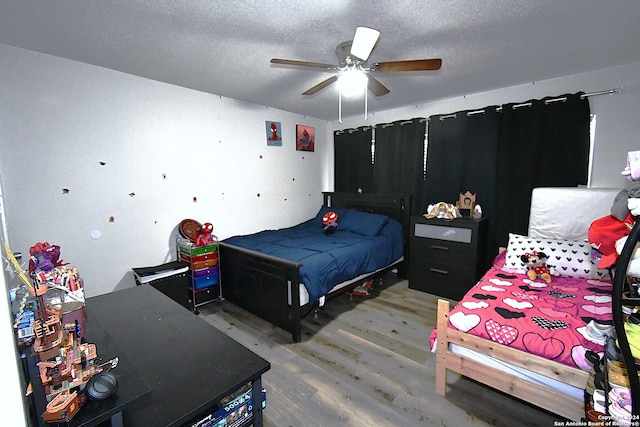 bedroom featuring ceiling fan, hardwood / wood-style flooring, and a textured ceiling